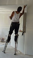 and the ceiling (the workman is using stilts to access the ceiling easily).